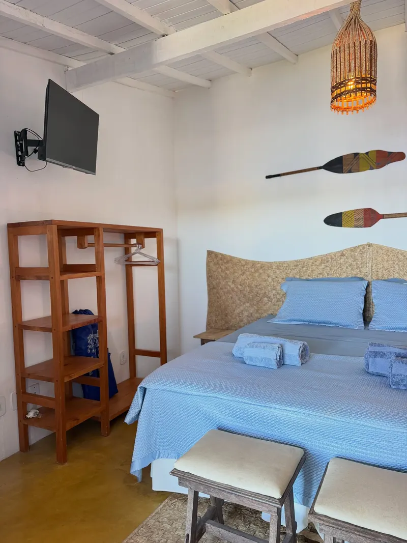 Quarto com TV, arara e ar-condicionado